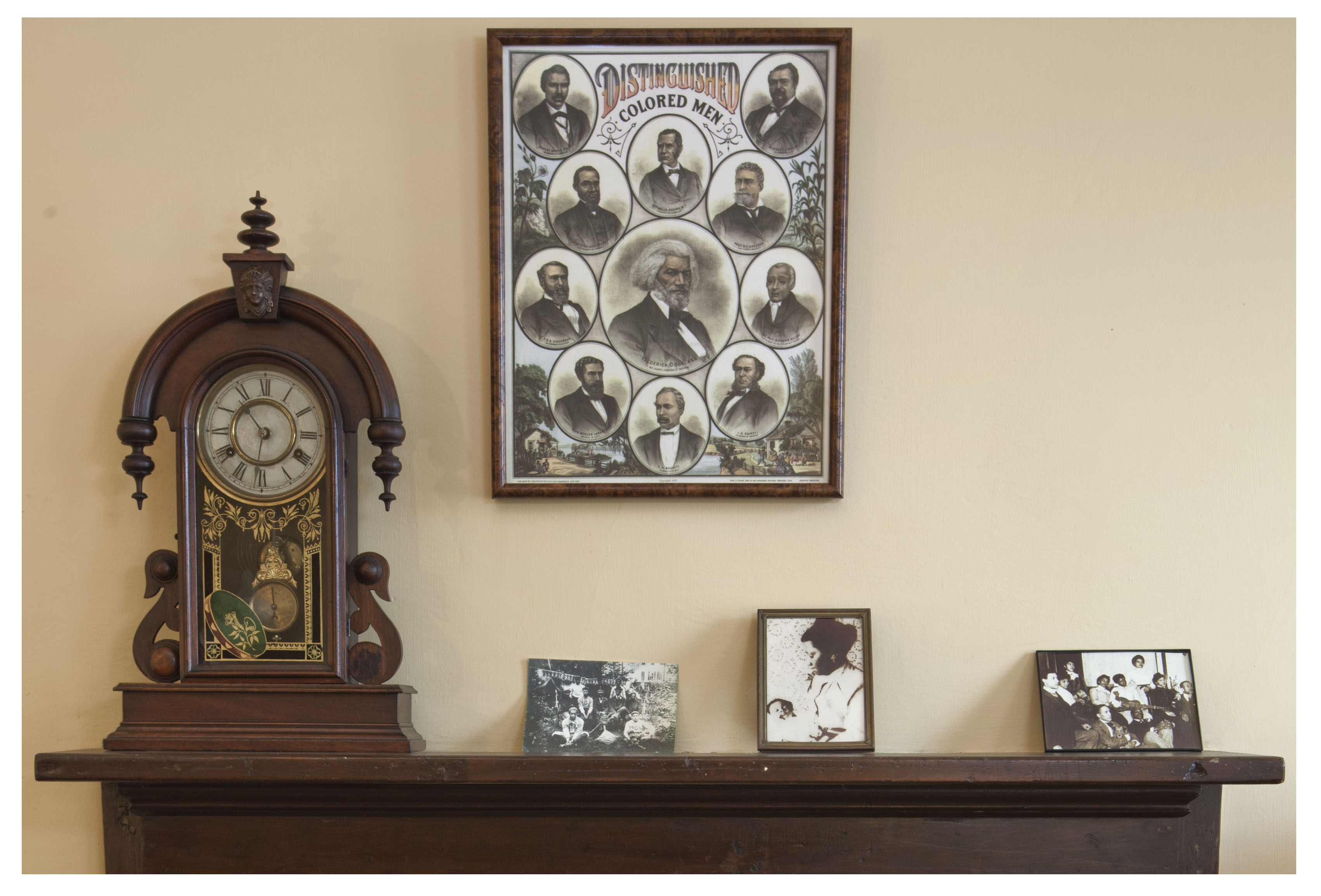 Mantelpiece with family photographs and a hand-colored lithograph of 'Distinguished Colored Men'